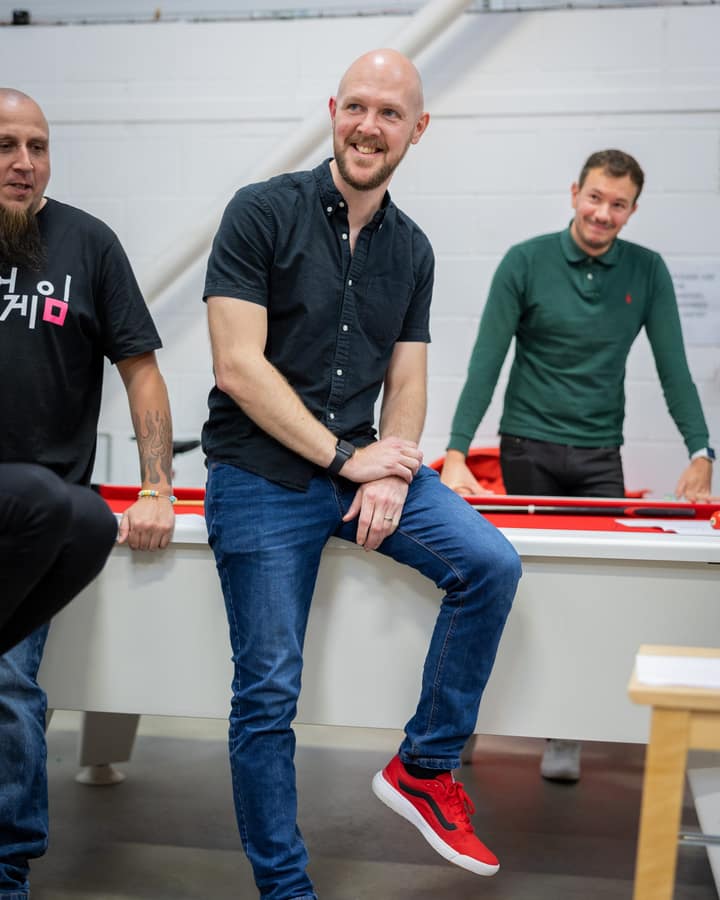 Liam O'Leary, Managing Director of Laser Red, smiling with colleagues in the Laser Red office